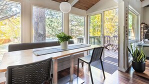 A dining area with a wooden table, chairs, and a potted plant.
