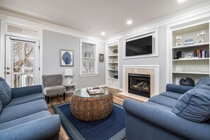 A living room with a fireplace, a television, and a bookshelf.