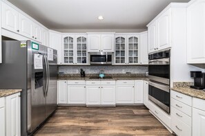 A kitchen with white cabinets, stainless steel appliances, and a granite countertop.