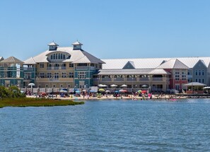 A waterfront hotel with multiple buildings, a beach, and umbrellas. - Sunset Island 53 Island Edge Drive (Ocean City)