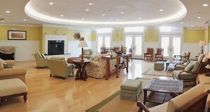 A spacious living room with a fireplace, multiple seating areas, and a dining table. - Sunset Island 53 Island Edge Drive (Ocean City)