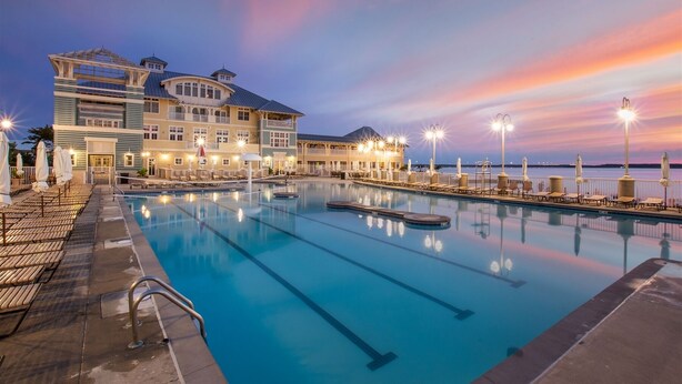 Un hotel con una grande piscina, diversi balconi e vista sul lungomare.