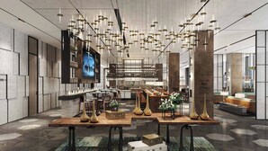 Een modern interieur met een centrale tafel waarop decoratieve objecten staan, een bar met krukken, en een groot scherm aan de linkerkant.
