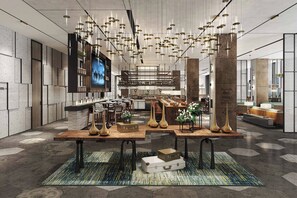 Un intérieur moderne avec une table centrale où sont exposés des objets décoratifs, un coin bar avec des tabourets et un grand écran situé sur le côté gauche.