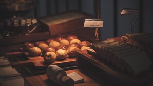 Een bakkerijdisplay met diverse broden en gebak, een bordje met de tekst 'White Toast' en een houten toonbank.