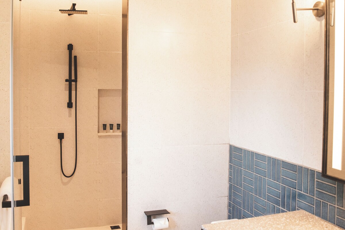 Une salle de bain moderne équipée d’une douche, de toilettes et d’un lavabo.