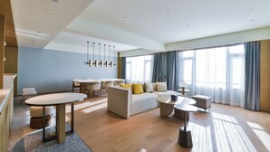 A modern hotel room with a living area, dining space, and large windows. - Crowne Plaza Beijing Badaling by IHG (Yanqing)