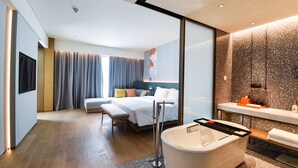 A modern hotel room with a large bed, a separate seating area, a bathtub, and a vanity with a mirror. - Crowne Plaza Beijing Badaling by IHG (Yanqing)
