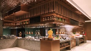 A modern kitchen with granite countertops, stainless steel appliances, and a central island with a decorative yellow sculpture. - Crowne Plaza Beijing Badaling by IHG (Yanqing)
