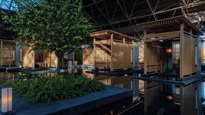 A modern indoor garden with a central tree, wooden structures, and a water feature. - Crowne Plaza Beijing Badaling by IHG (Yanqing)