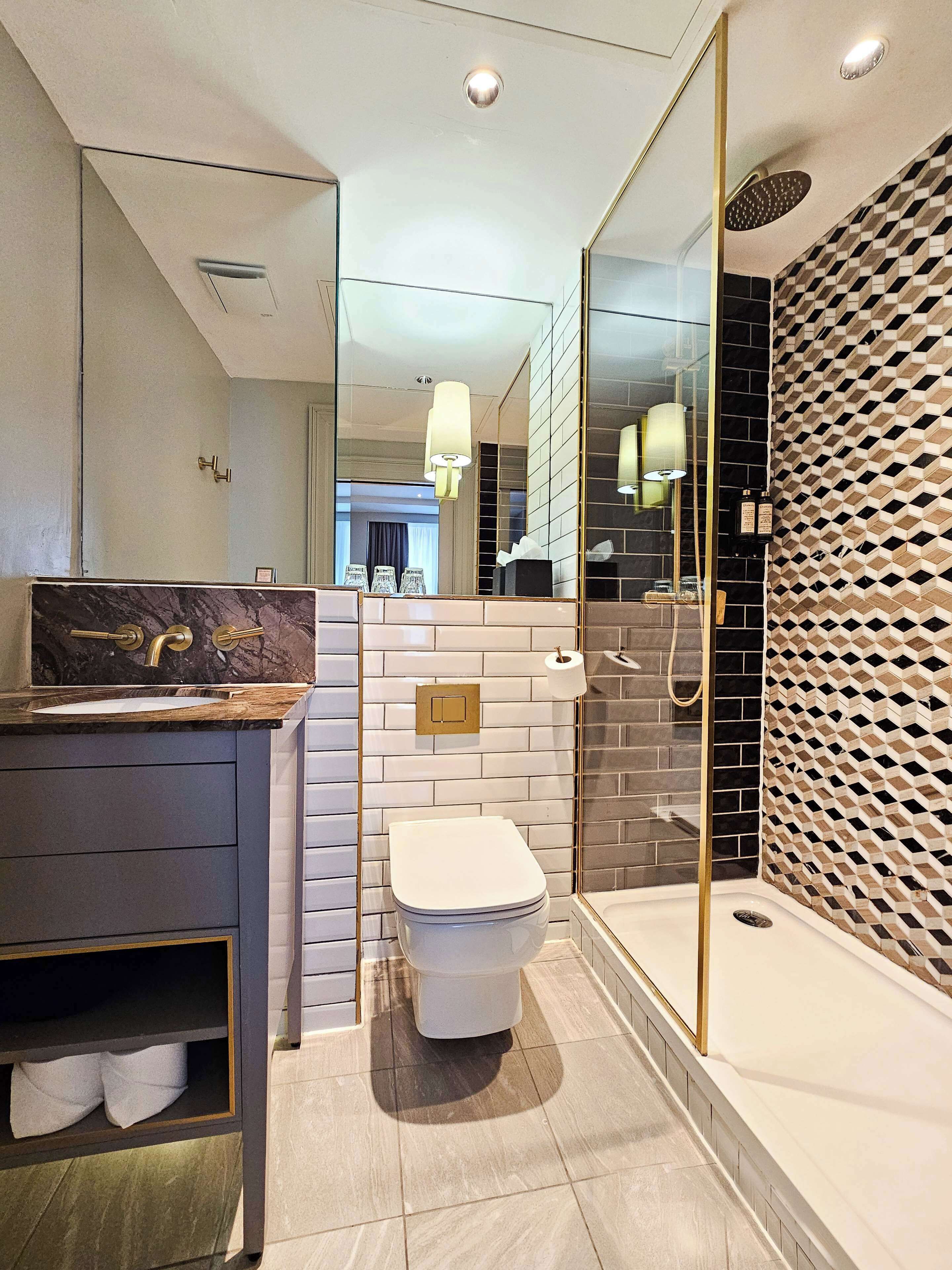 A modern bathroom with a toilet, sink, and shower area.