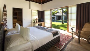Une chambre avec un grand lit, une télévision, un bureau et une vue sur une piscine et la maison, à l’extérieur.