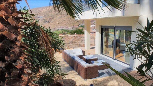 A modern villa with a sun terrace, outdoor seating, and a view of the surrounding landscape. - Villa André con Piscina, Barbacoa, Wifi & Satélite (Vícar)