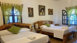A room with two wooden beds, green curtains, and wall-mounted artwork. - Casa El Delfin, 1st Floor - Main Level- Estacahuite (Estacahuite)