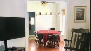 A dining area with a red table, chairs, and a television on a stand. - 3 bedroom/1.5 bath Baseball rental 6 minutes to Cooperstown All star village.  (Oneonta)