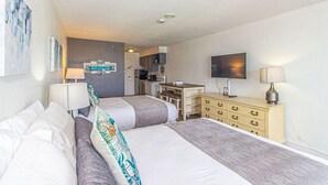 A hotel room with two beds, a desk, a television, and a kitchenette. - Sea Mist 51610 (Myrtle Beach)