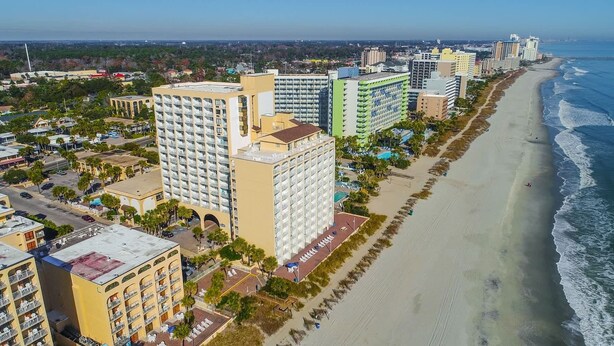 A coastal cityscape with high-rise hotels, a beach, and a clear sky. - Sea Mist 51610 (Myrtle Beach)