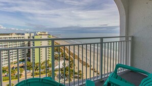 A balcony with a view of the beach and ocean, a parking area, and a building with multiple floors. - Sea Mist 51610 (Myrtle Beach)
