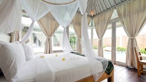 A large bed with white linens, a canopy, and a view of a pool and greenery outside. - At Last, Rent Your Own 5 Star Private Villa in Seminyak at an Affordable Rate, Bali Villa 1145 (Bali)