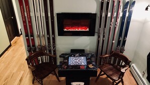 A room with skis on the wall, a TV, and a table with a game. - The Heart of Fraser (Fraser)