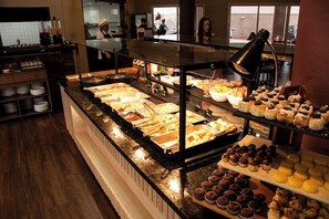A buffet with various food items, including pastries and desserts, arranged on a counter. - Lummina Hotel (Barueri)