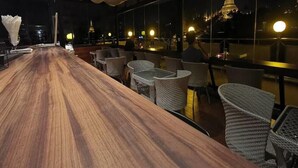 An outdoor bar area with a long wooden counter and wicker chairs. - Hotel Lavender (Yangon)