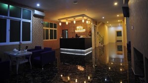 A hotel lobby with a reception desk, seating area, and a staircase. - Hotel Lavender (Yangon)