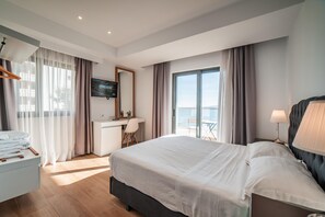 A modern hotel room with a large bed, a desk, a television, and a balcony with a view. - Epirus Hotel (Sarandë)