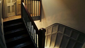 A staircase with wooden steps and a handrail, leading to a door at the top. - The William IV (London)