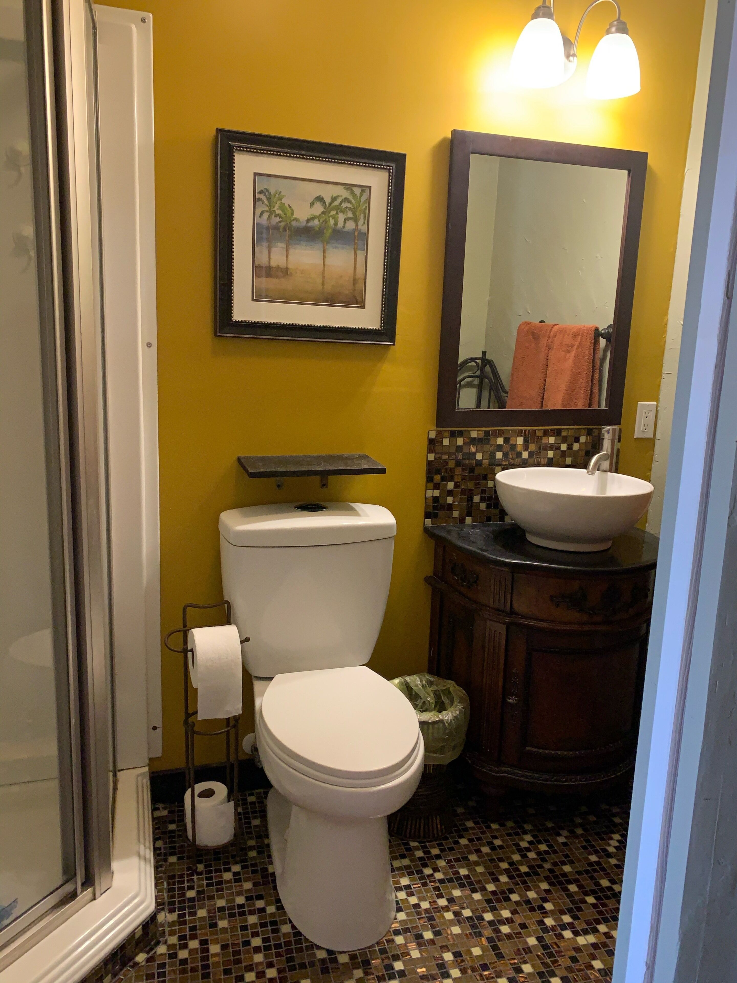 Une salle de bain avec des toilettes, un lavabo et un tableau encadré au mur.