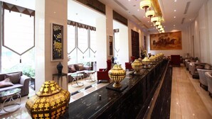 A spacious lobby with a long reception desk, comfortable seating areas, and large windows allowing natural light. - Inner Mongolia Hotel Forbidden City (Beijing)