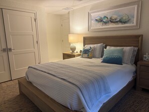 A bedroom with a bed, nightstands, a lamp, and a framed artwork on the wall. - NEWLY RENOVATED!!! Anna Maria Island - Key Royale - Dock/Lift - Heated Pool/Spa (Holmes Beach)