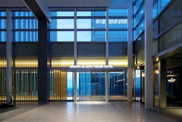 The entrance of Nagoya JR Gate Tower Hotel with a modern design, large glass windows, and a well-lit interior.