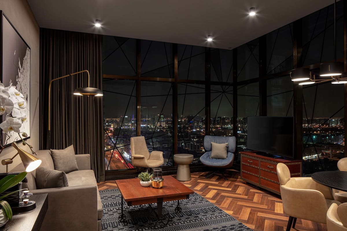 A modern living room with a city view, a sofa, a coffee table, and a TV.