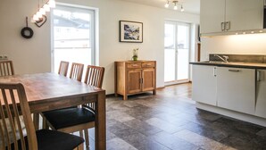 Une cuisine moderne avec une table à manger en bois, des chaises et des placards.