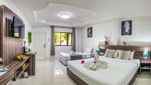 Habitación de hotel con una cama grande, un escritorio con silla, un televisor montado en la pared y una ventana con cortinas.