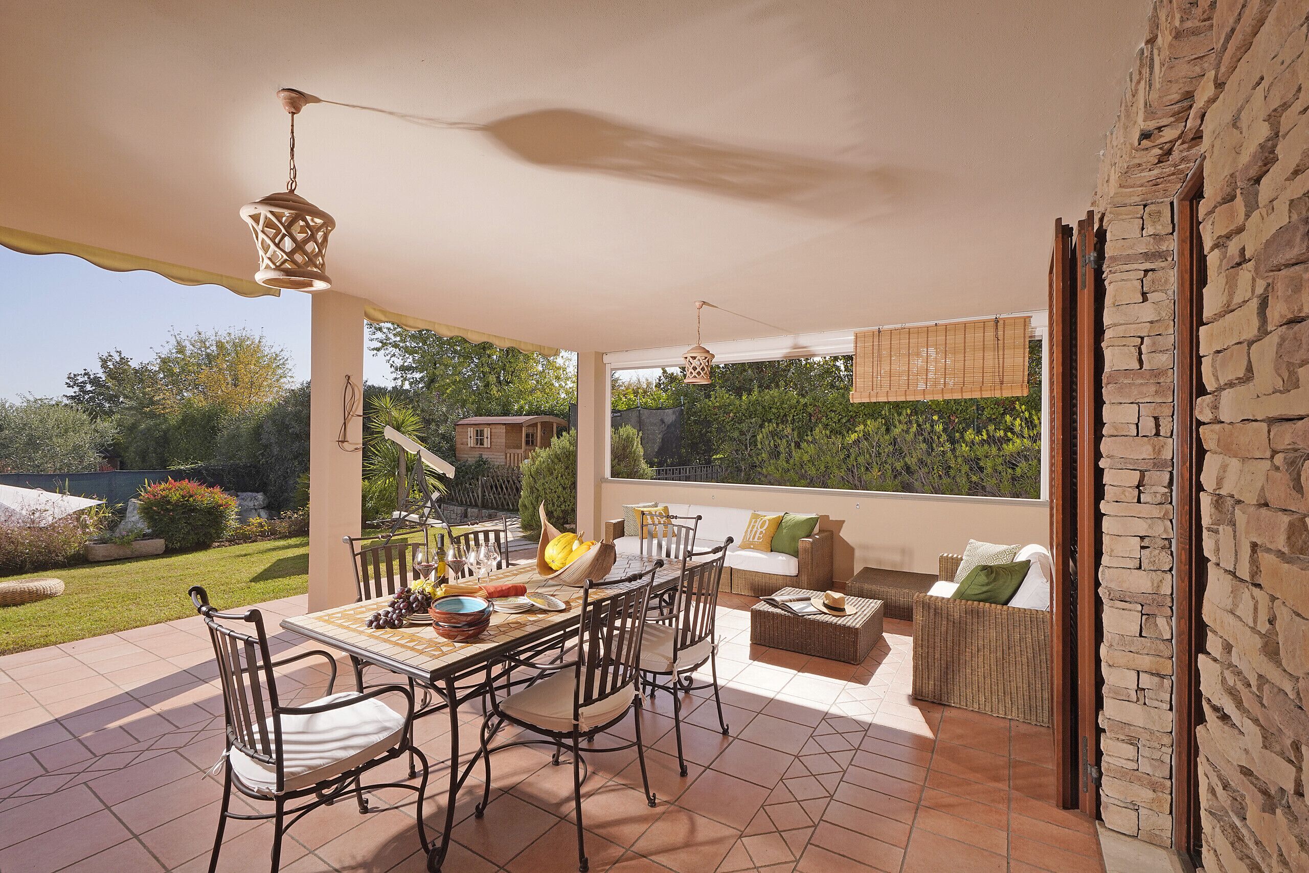 An outdoor patio with a dining table, chairs, and a sofa.