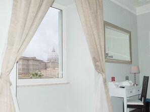 A room with a large window, a desk with a mirror, and a lamp. - Chez Alice Vatican (Rome)