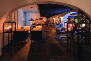 An indoor dining area with stone flooring, tables, chairs, and candle-lit tables. - Movenpick Zurich Regensdorf (Regensdorf)