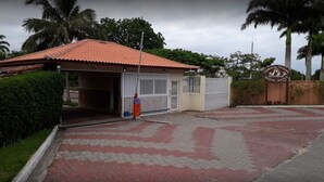 A gated entrance to a building with a red-tiled roof and a sign indicating 'Colégio Estadual Santa Maria'.