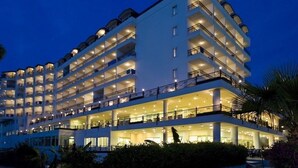 A multi-story hotel with balconies on each floor, large windows, and a well-lit facade. - Perre Delta Hotel (Alanya)