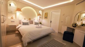 Une chambre à coucher moderne avec un grand lit, des tables de chevet, une commode et un miroir.