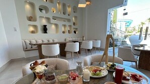 Un comedor con una mesa redonda de cristal, distintos productos para el desayuno y una decoración de estilo moderno.