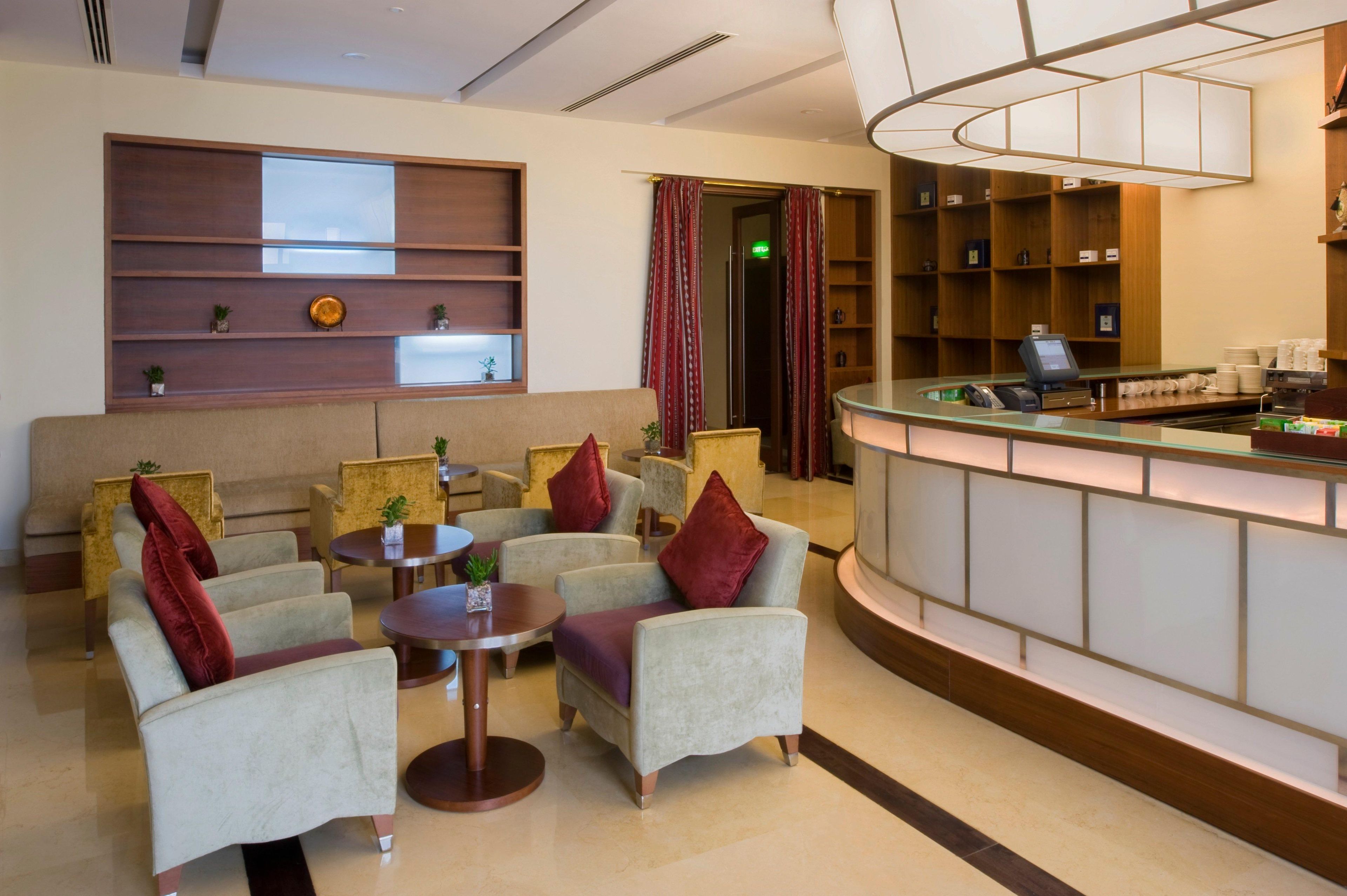 A lobby with seating, a reception desk, and a wall with shelves.