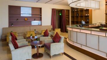 A lobby with seating, a reception desk, and a wall with shelves.