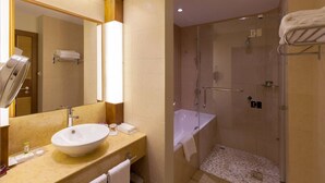 Un baño moderno con un lavamanos grande, espejo y cabina de ducha.