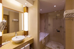Un baño moderno con un lavamanos grande, espejo y cabina de ducha.