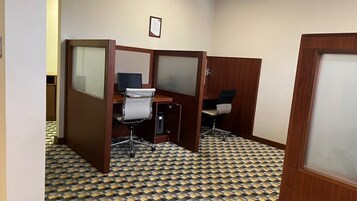 Una habitación con suelo a cuadros, separadores de madera y sillas de oficina.