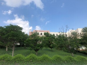 A building with a sign reading 'CROWN PLAZA' amidst greenery. - Crowne Plaza Sohar (Sohar)