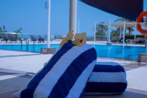 A poolside area with a towel and a flower decoration. - Crowne Plaza Sohar (Sohar)